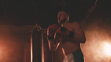 shirtless boxer man warms up by punching the air 2