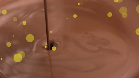 animación de puntos dorados sobre el derramamiento de chocolate