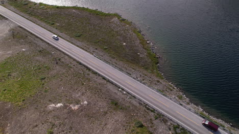 cars driving along riverside road towards geirangerfjord in geiranger area in norway, aerial view