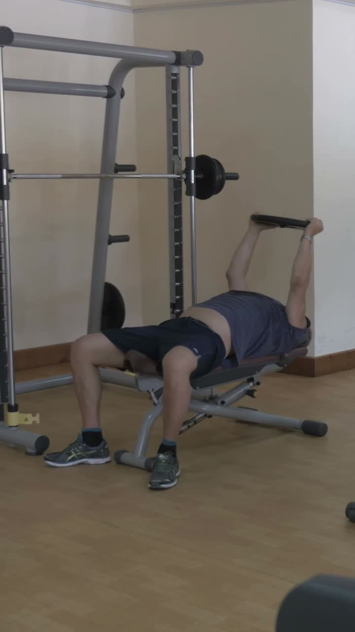 Spor salonunda başının üzerinde ağırlık kaldıran adam