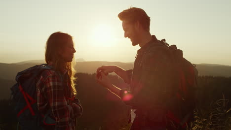 man proposing marriage to woman at sunset in the mountains