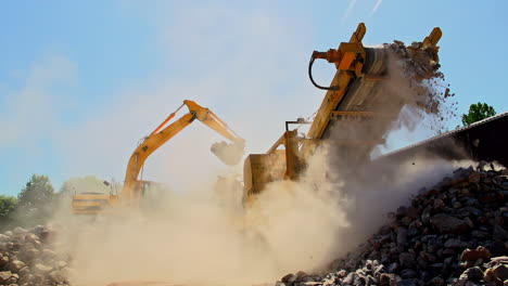 toma en cámara lenta de grúa y transportador que transporta rocas y arena con polvo a la luz del sol - ángulo bajo