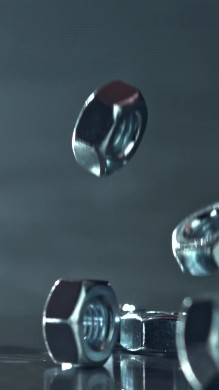 Shiny Metal Nuts Falling in Slow Motion