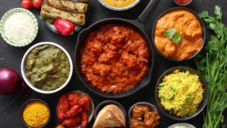 various indian dishes on a table  spicy chicken tikka masala in iron pan