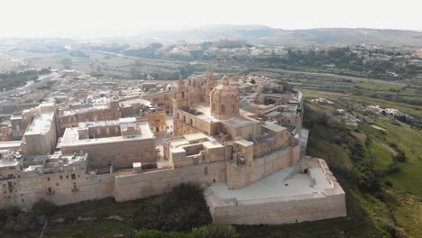 panoramic view outside the mdina city fortifications of metropolitan cathedral of saint paul - fly-forward aerial shot