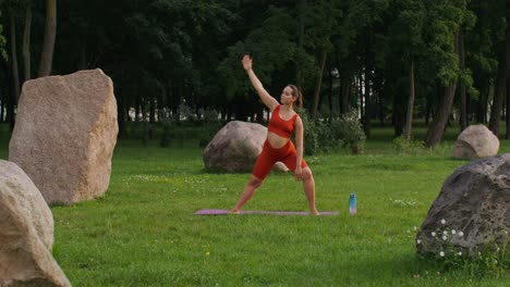 mujer embarazada haciendo yoga en un parque