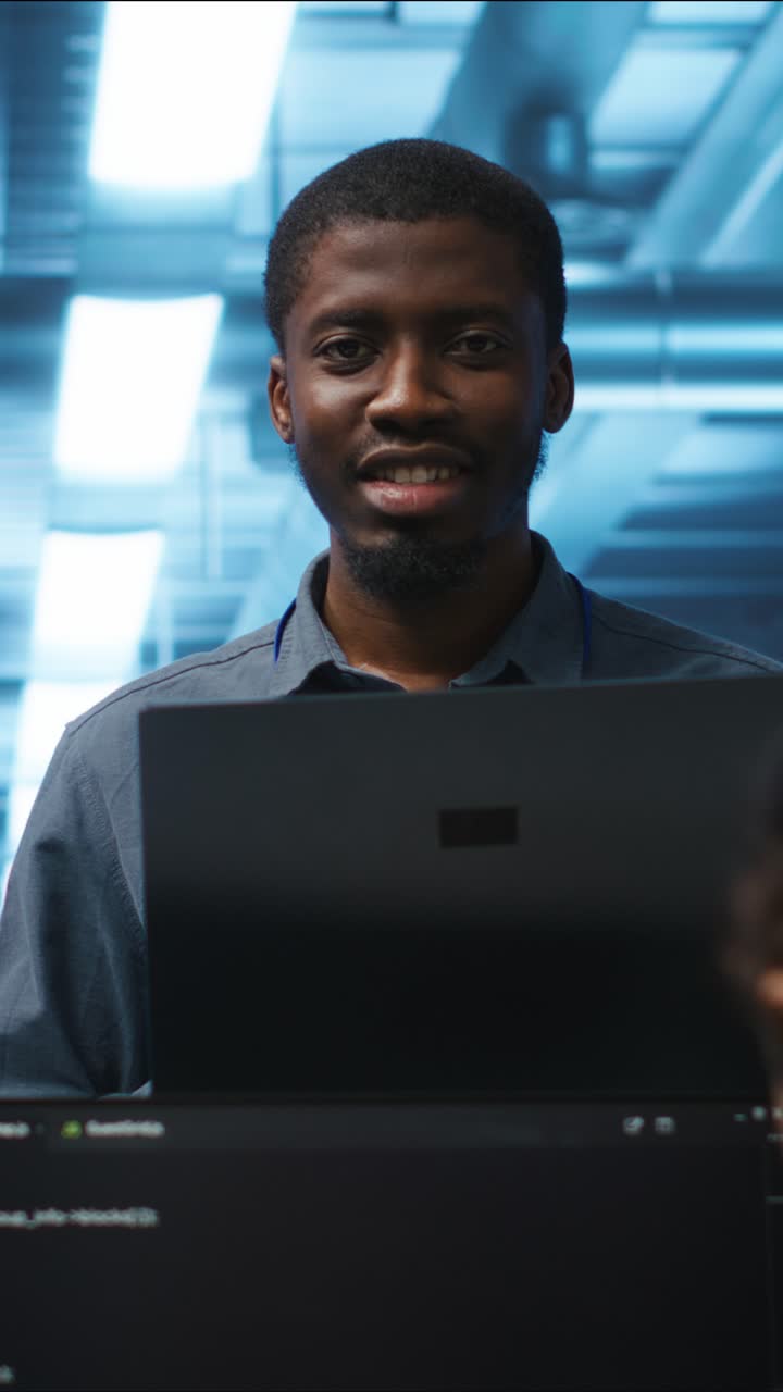 Young African American Programmer Working on Laptop in Data Center