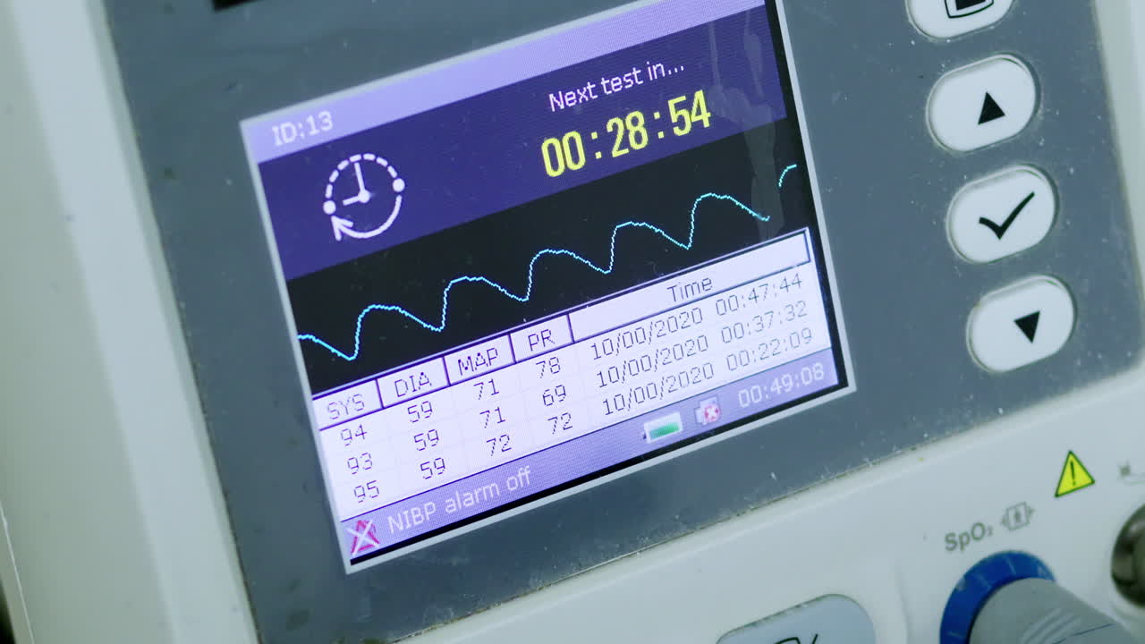 A close-up view of a healthcare monitoring device displaying vital signs in a clinical environment
