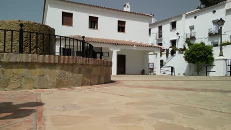 Clip-of-drone-landing-on-tiled-ground,-showing-traditional-whitewashed-building