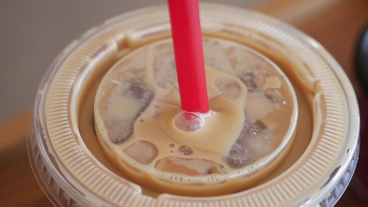 Caffe' ghiacciato in una tazza di plastica con paglia