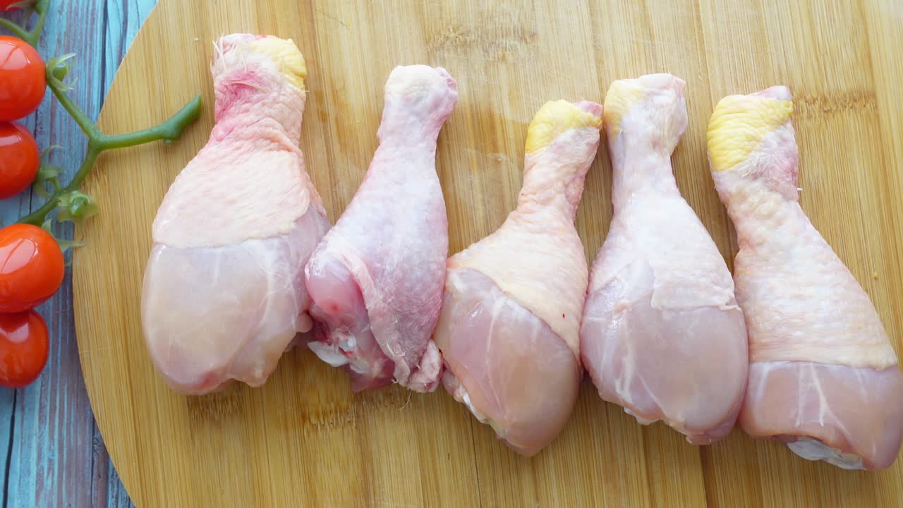 Raw Chicken Drumsticks on a Wooden Cutting Board