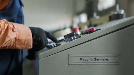 man working on the control panel works with an industrial machine at the factory close-up.