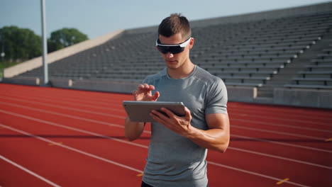 athlete using smart glasses and tablet on a running track