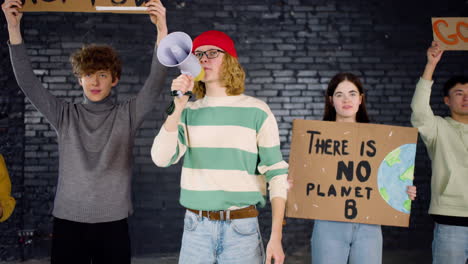 young environmental activists with placards and megaphone protesting against climate change inaction