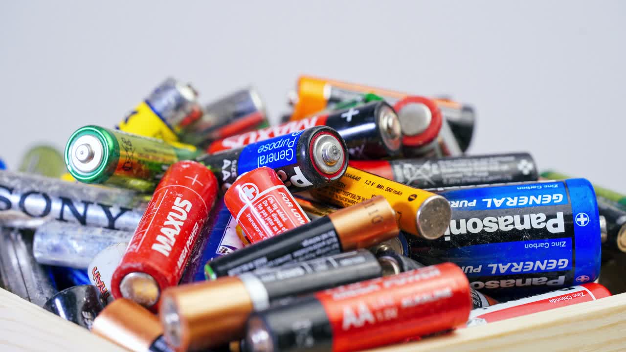Used batteries preparing for recycling. Many used AA and AAA size batteries in a pile.
