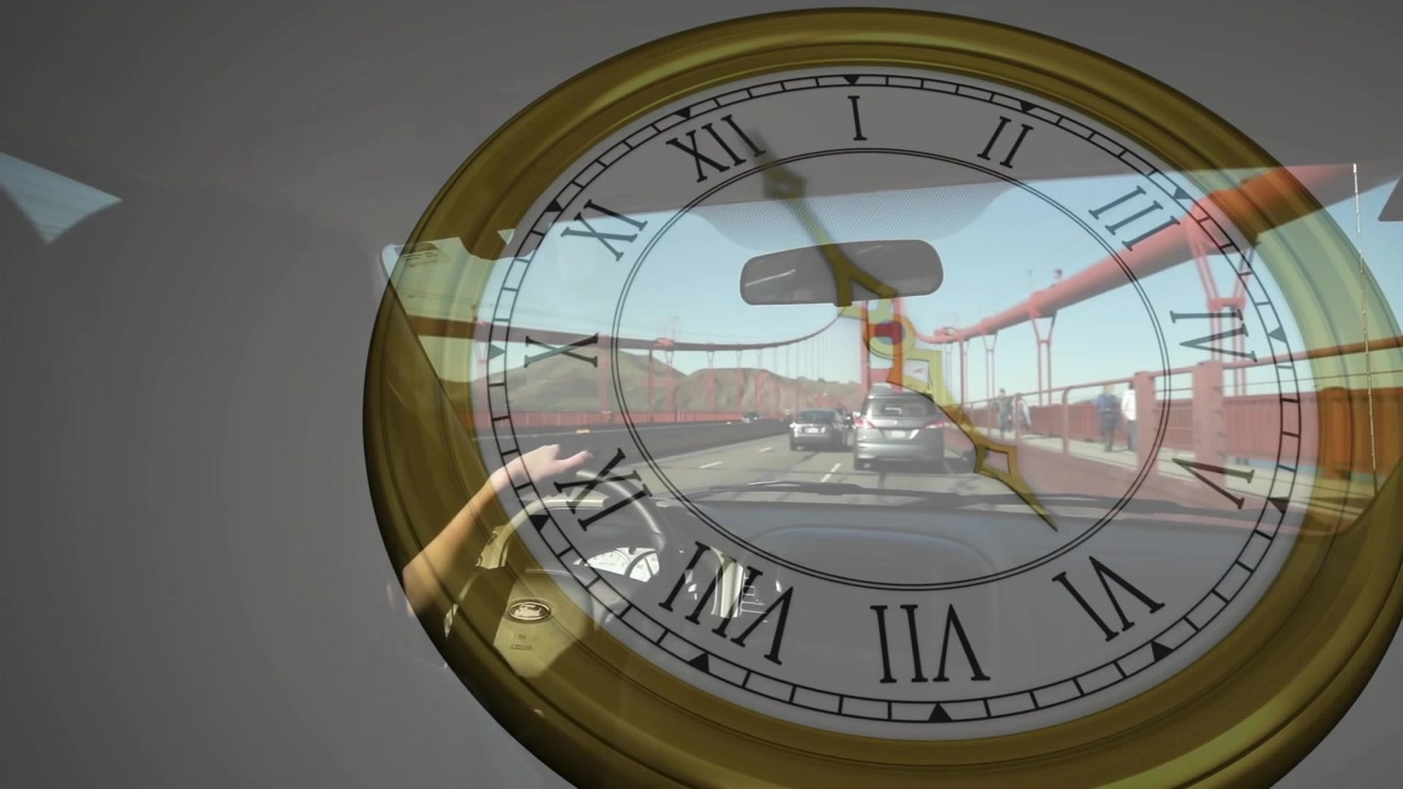 Conduciendo, mujer agarrando el volante, con una superposición de reloj analógico que se extiende por el Puente Golden Gate.