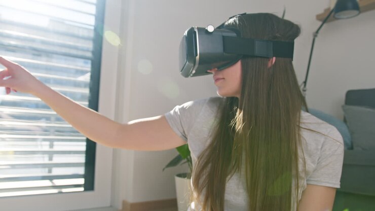 Girl wearing a VR headset, moving her hand on the VR screen, handheld shot