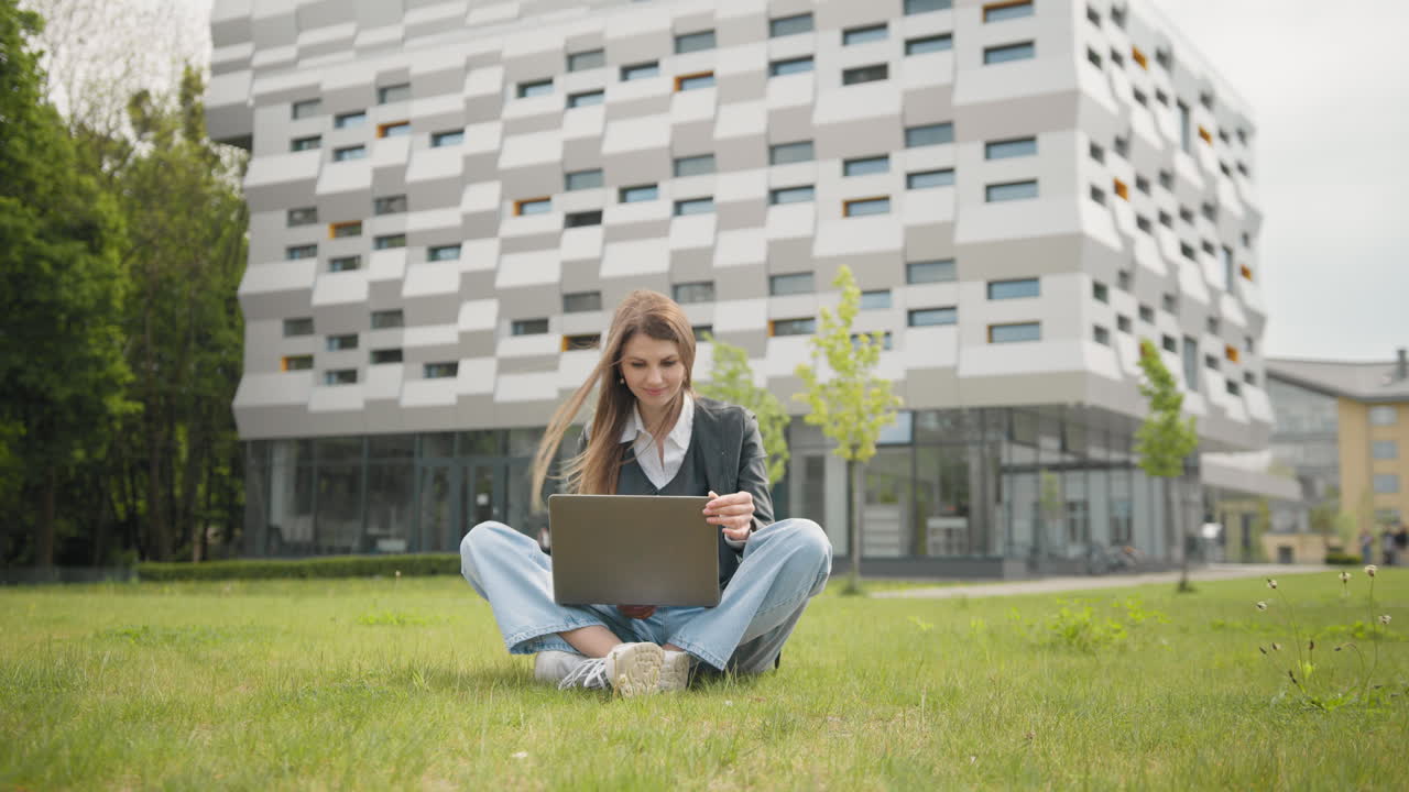 Felice studentessa universitaria che riceve buone notizie sul laptop.