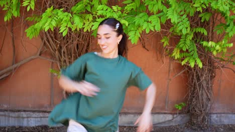 Woman dancing by a wall with leaves