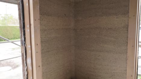 inside tilt down view of a hempcrete wall corner in wooden frame unter construction