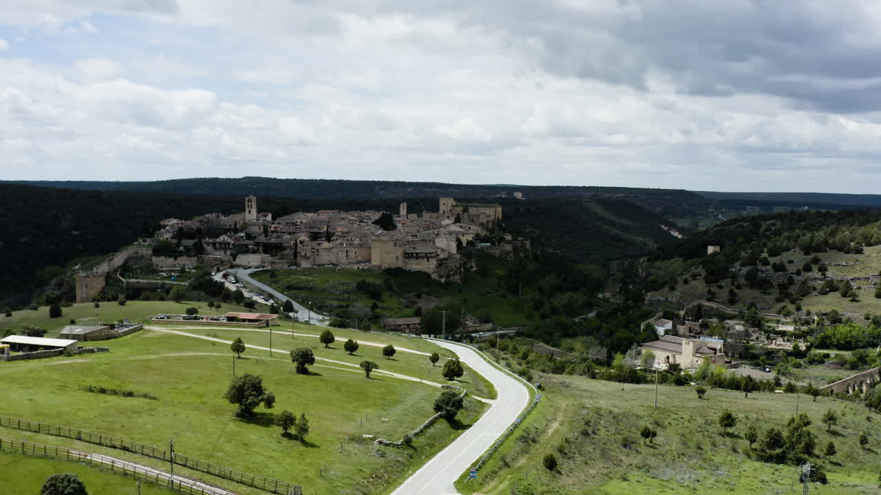 vista lejana de la ciudad amurallada de pedraza rodeada de un paisaje verde en segovia, españa
