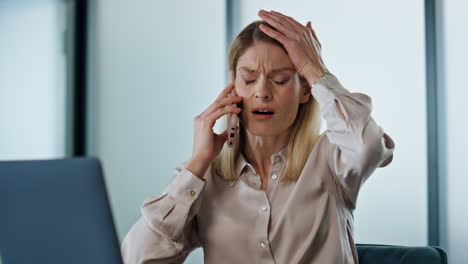 annoyed business woman calling phone at work desk closeup. angry ceo facepalming