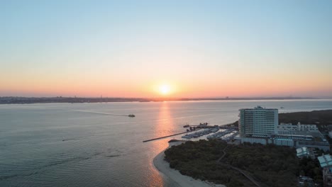 amanecer sobre un bonito lago temprano en la mañana con algunos barcos navegando, colorido amanecer naranja