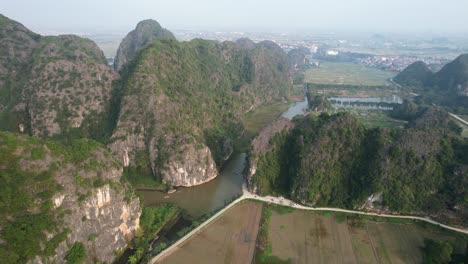 ngo dong river weaving in limestone mountains valley in ninh binh vietnam at sunset - aerial descending