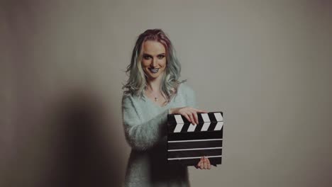 film production and movie making concept. portrait of young pretty woman with clapperboard.