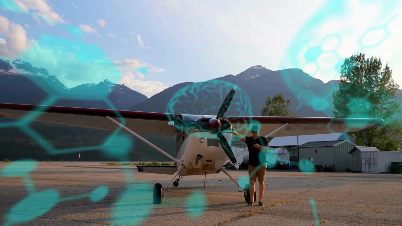 Pilota che controlla lo smartphone su una pista di aviazione, mostrando sovrapposizioni esagonali turchesi basate sui dati