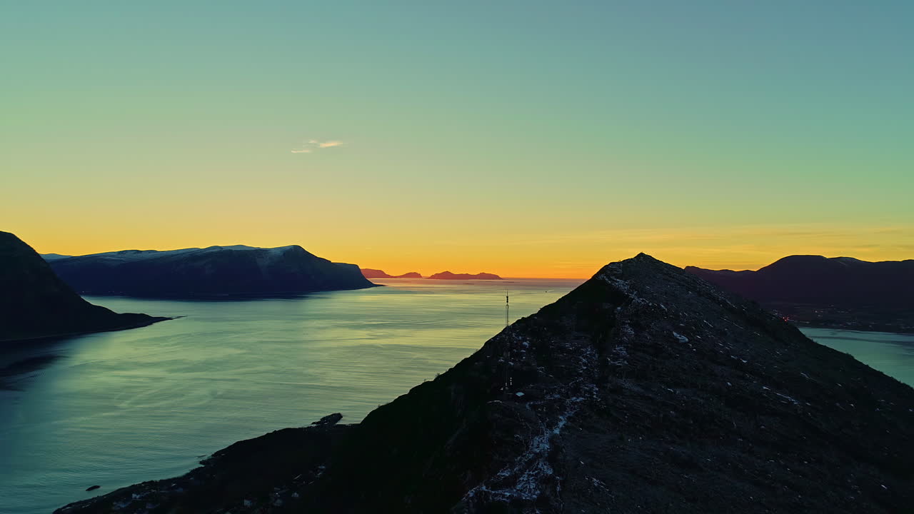 Stunning view of beautiful mountains and orange sunset revealing a lake in Norway
