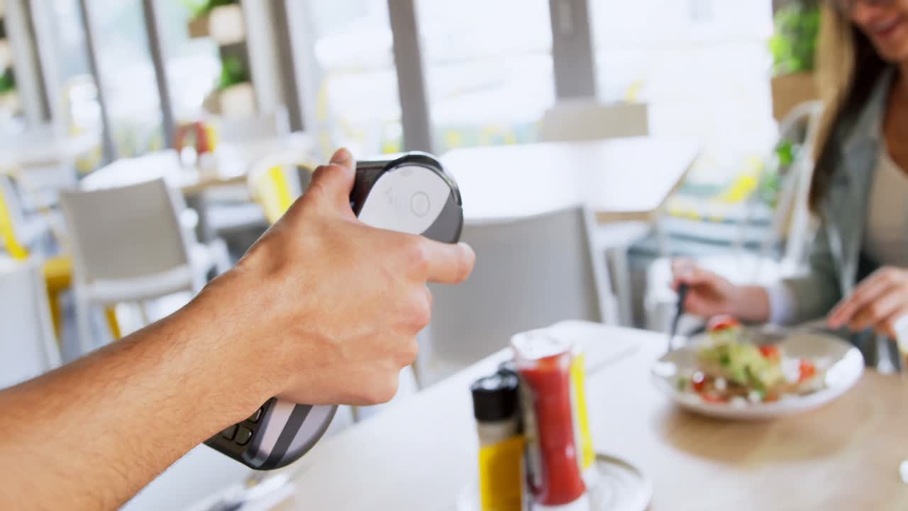 camarero tomando el pago por smartwatch 4k