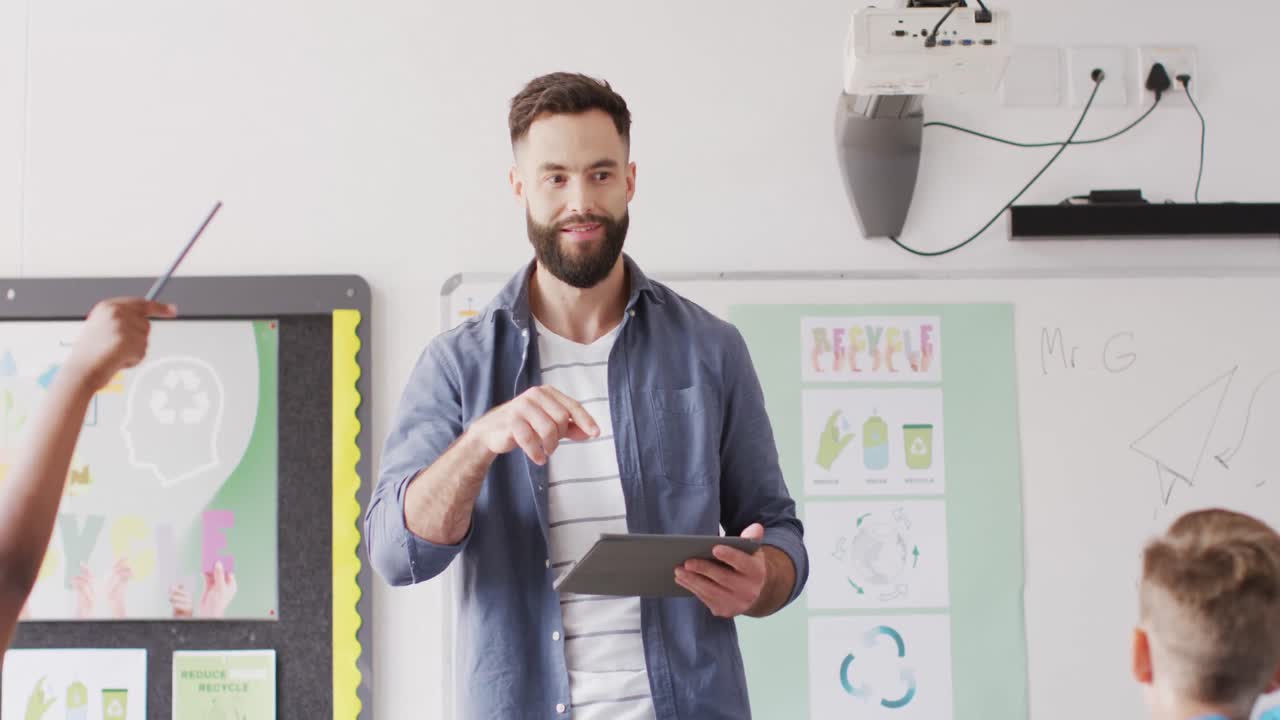 maestro masculino diverso y escolares felices en el escritorio en el aula de la escuela