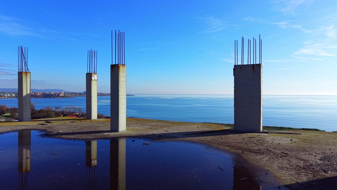 Vue depuis les toits de tunnels de serre et du littoral, Pomorie, Bulgarie. Un angle zénithal capture des polytunnels blancs, des cabanes, des terres agricoles et une mer turquoise calme. Vue aérienne d'un chantier de construction.