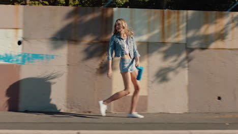 beautiful woman painting wall with blue paint walking in city street independent female artist enjoying artisitic expression with urban graffiti art