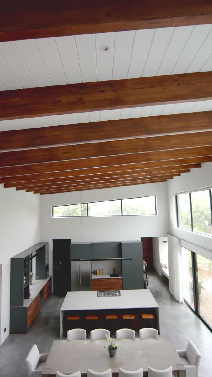 Vertical video of open plan living room, dining room and kitchen, copy space, slow motion