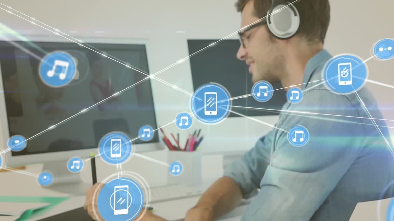 Animazione di una rete di icone digitali su sfondo di un uomo caucasico che usa una tavoletta grafica in ufficio