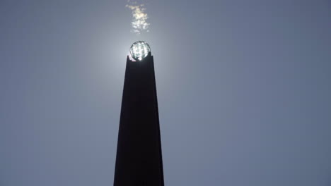 sun disappearing behind iron and crystal obelisk