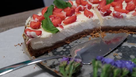 close-up of fresh homemade cheesecake with strawberries and mint on metal tray, 4k