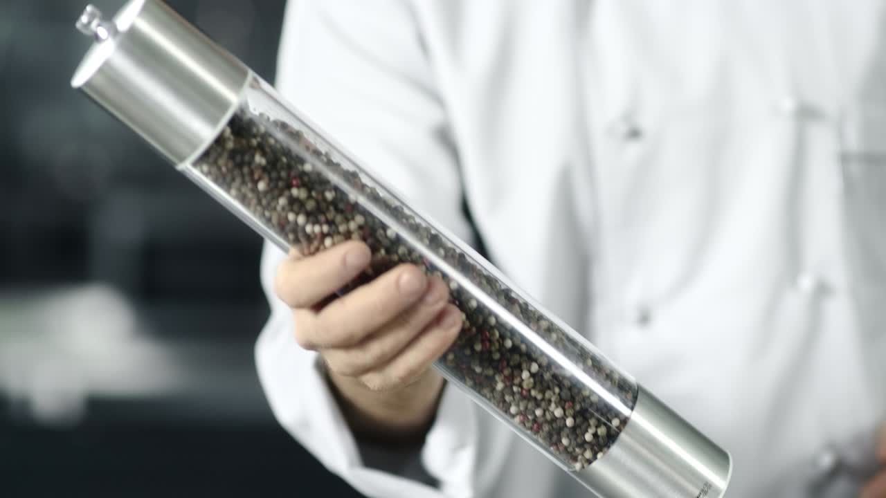 부 ⁇ 에서 페퍼박스를 가진 남성 요리사. 클로즈업 남자의 손이 페퍼박스를 가지고 놀고 있습니다.