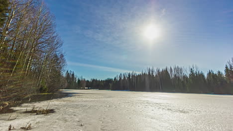 time lapse shot of beautiful sunrise over frozen lake in wilderness during winter day