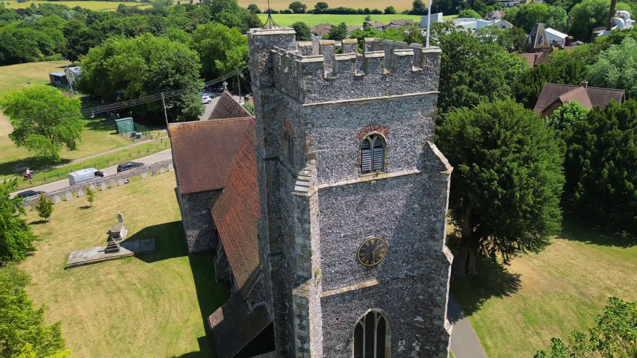 An upward-tilt shot of St Mary's church in Chartham, tilting up to reveal the union flag flying from the tower