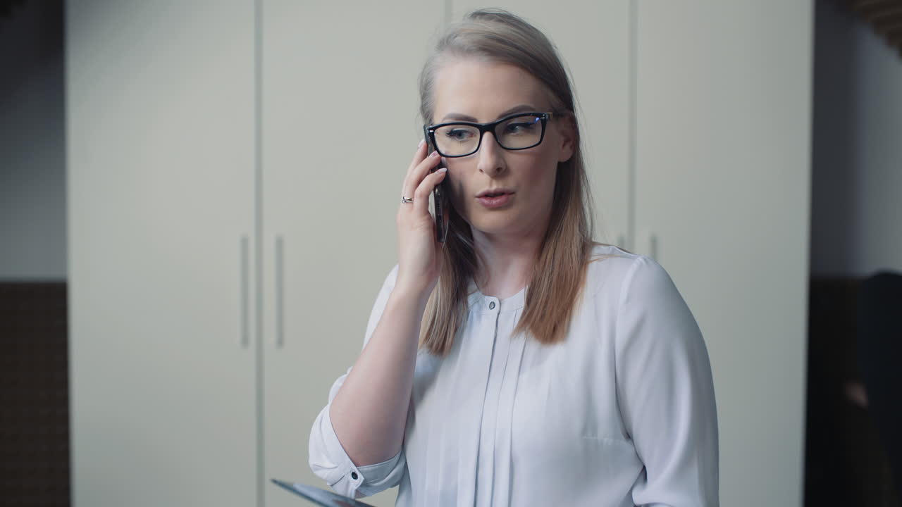 Kvinne snakker i telefonen og diskuterer forretningssaker med klient