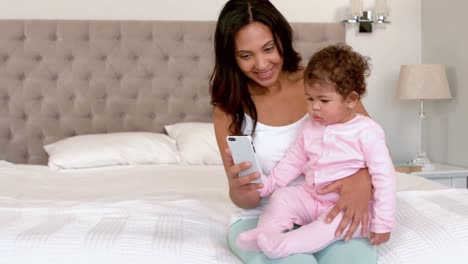 Mother-with-her-cute-baby-using-samrtphone