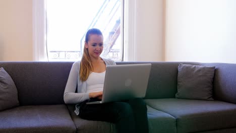 mujer usando computadora portátil en la sala de estar