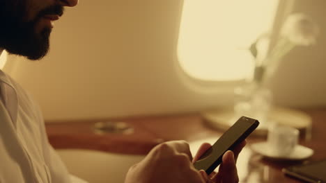 arabian businessman holding smartphone with chroma key screen in hands closeup.