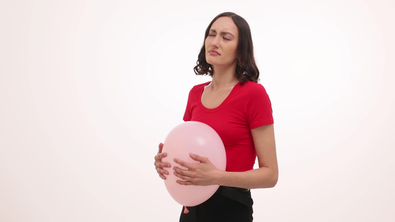 Woman Experiencing Abdominal Discomfort with a Pink Balloon