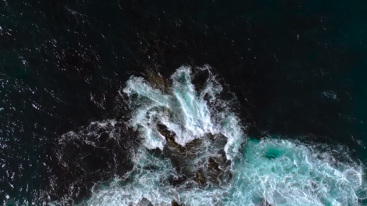 Aerial View of Waves Crashing on Rocky Coast