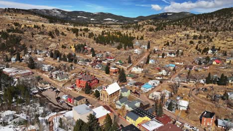 historic downtown neighborhood streets buildings central city black hawk colorado aerial drone view city townhall winter sunny daytime blue sky gold mining town tailings casinos backwards upwards