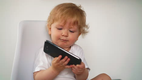 toddler blonde tries to take huge smartphone